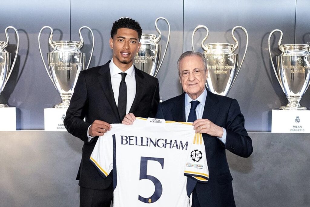 Jude Bellingham con Florentino Pérez sosteniendo la camiseta del jugador durante su presentación con el Real Madrid.