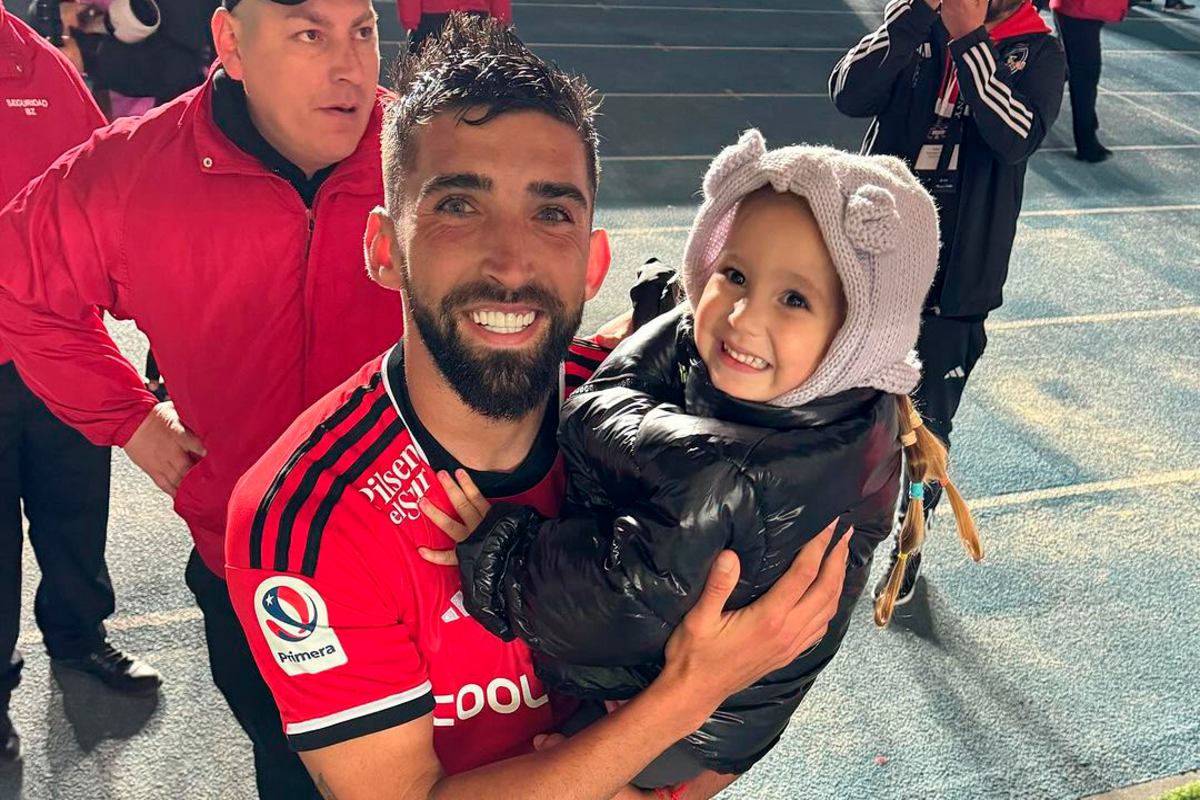 Emiliano Amor sonriendo junto a su hija tras concretar su primer partido oficial con la camiseta de Colo-Colo durante la temporada 2023, luego de un año fuera de las canchas por lesión.