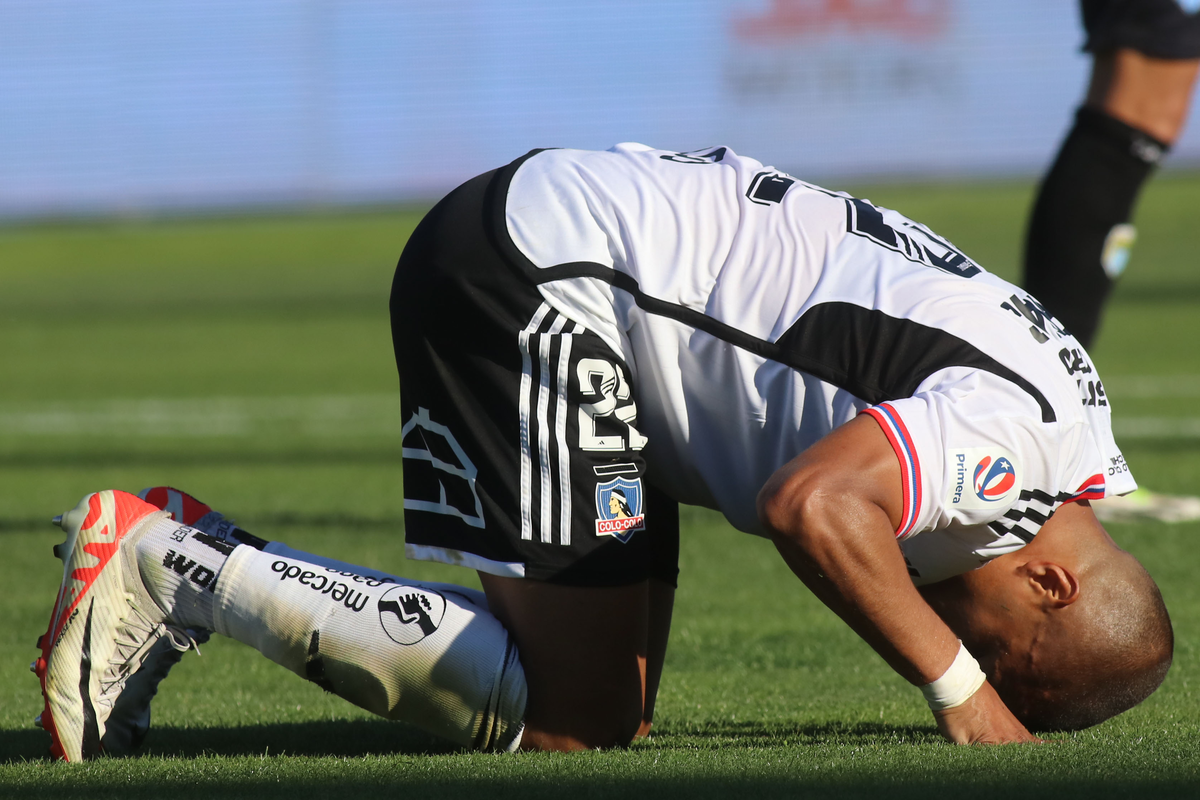 Leandro Benegas de rodillas y su cabeza en el piso se lamenta con la camiseta de Colo-Colo durante la temporada 2023.