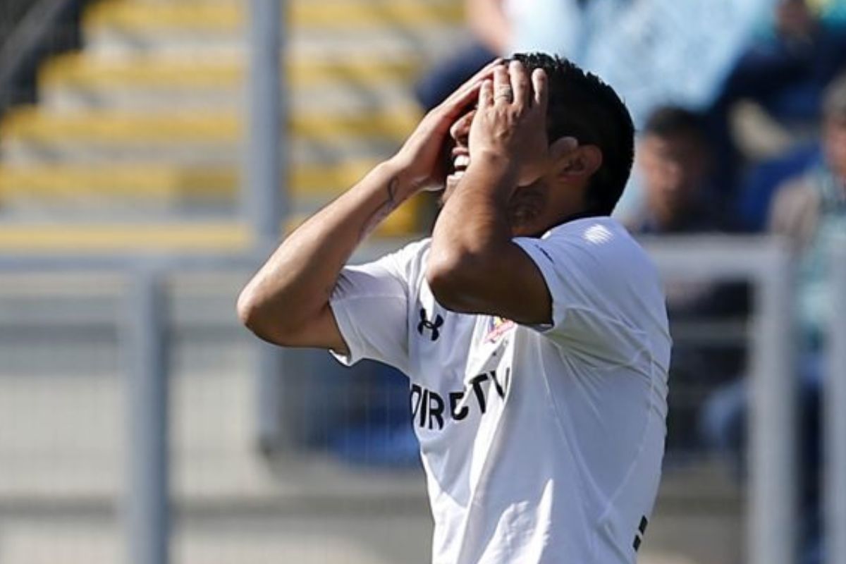 Nicolás Maturana tomándose la cabeza mientras usa la camiseta de Colo-Colo
