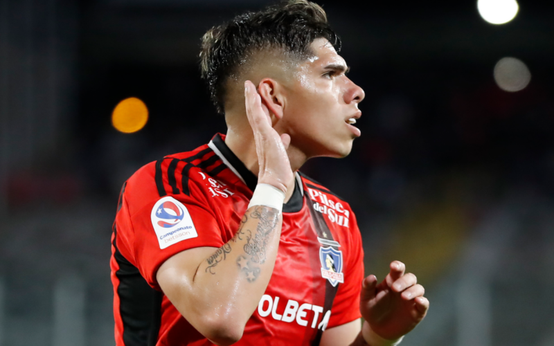 Carlos Palacios se toma la oreja con una mano en plena celebración de un gol con la camiseta de Colo-Colo durante la temporada 2023.