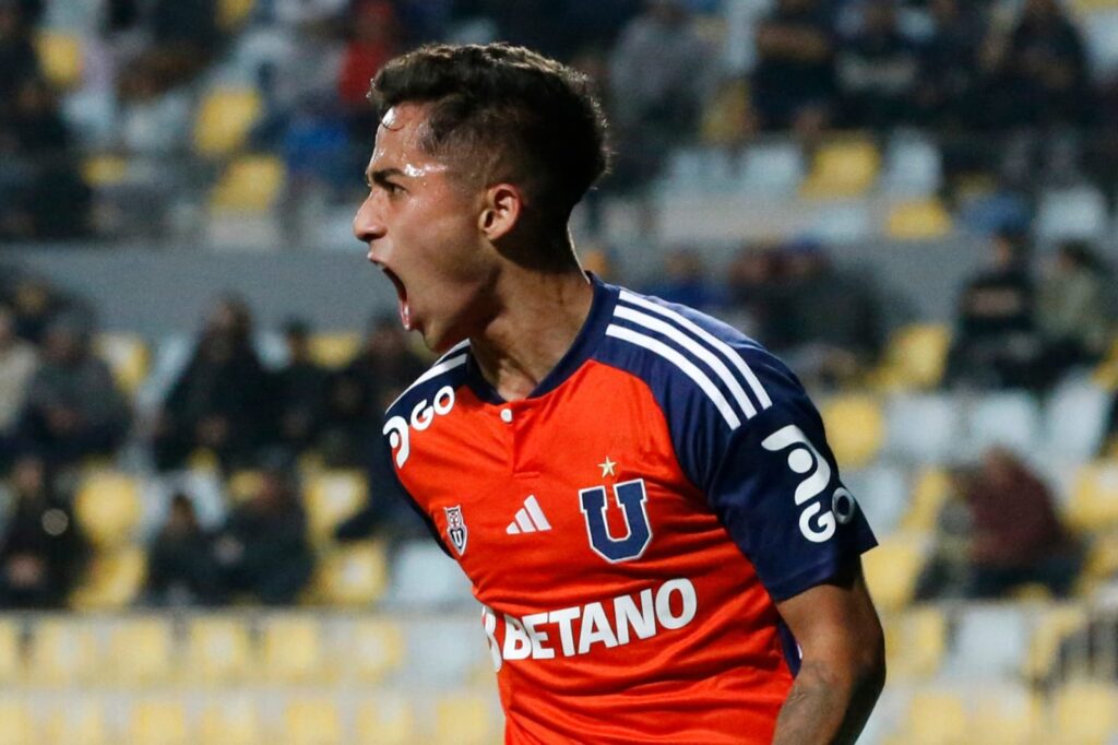 Primer plano a Lucas Assadi celebrando un gol con la camiseta de Universidad de Chile.