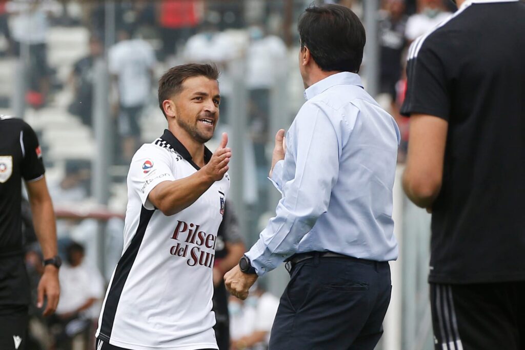 Gustavo Quinteros y Gabriel Costa saludándose durante un partido de Colo-Colo en el Estadio Monumental.