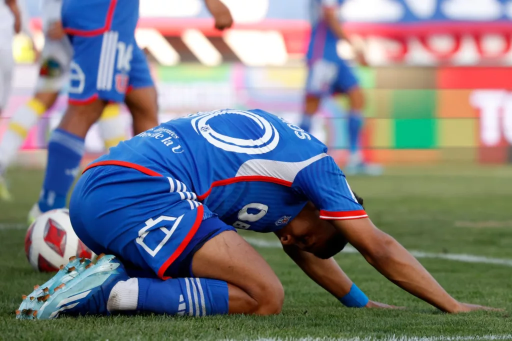 Primer plano a jugador de Universidad de Chile tendido sobre el piso.