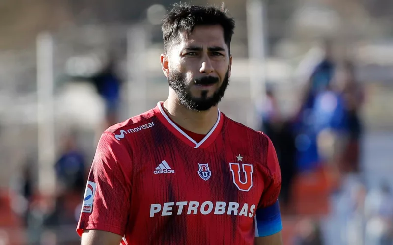 Primer plano a Johnny Herrera en un campo de juego con camiseta de Universidad de Chile y cara de preocupación.