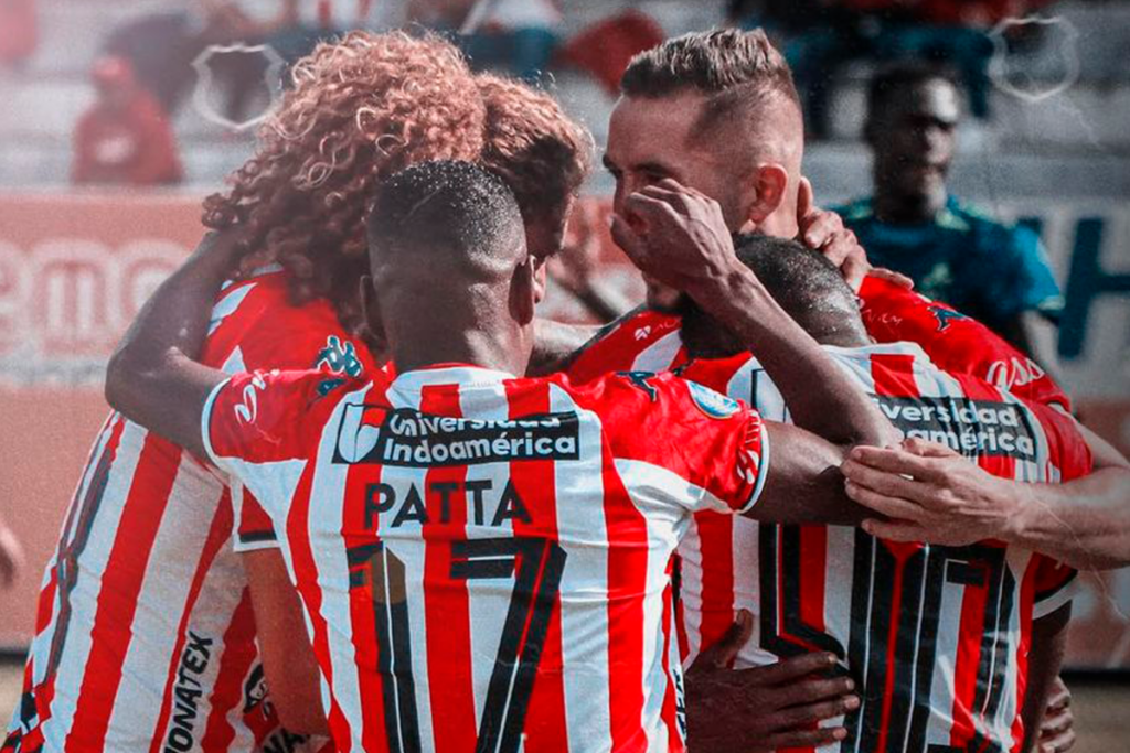 Futbolistas de Técnico Universitario de Ecuador se abrazan y celebran un gol durante la temporada 2023.