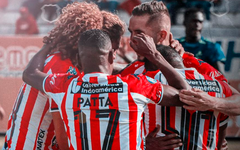 Futbolistas de Técnico Universitario de Ecuador se abrazan y celebran un gol durante la temporada 2023.