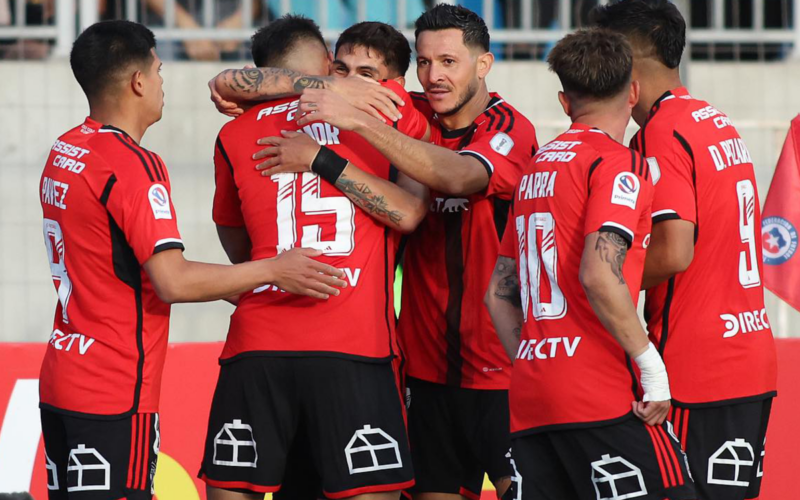 Futbolistas de Colo-Colo se abrazan y celebran un gol durante la temporada 2023.