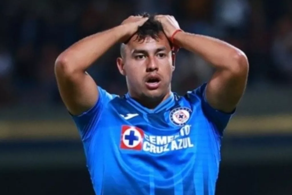 Iván Morales tomándose la cabeza mientras juega un partido por Cruz Azul.