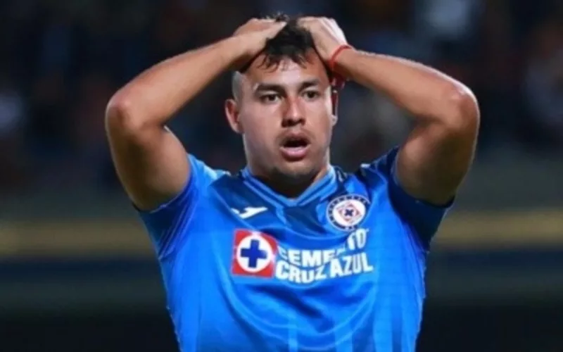Iván Morales tomándose la cabeza mientras juega un partido por Cruz Azul.