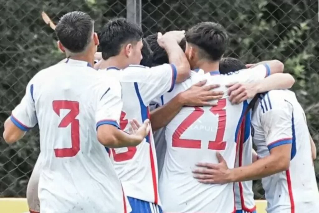 Jugadores de la Selección Chilena Sub 20 abrazándose celebrando un gol.