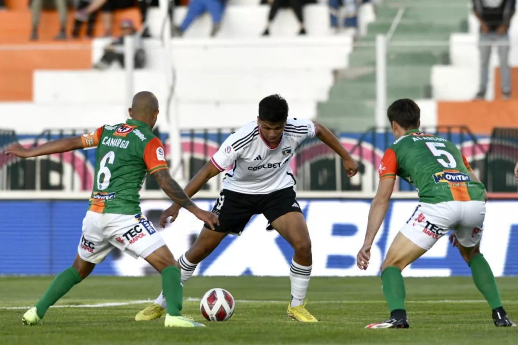 Damián Pizarro siendo marcado por Alejandro Camargo y Francisco Alarcón.