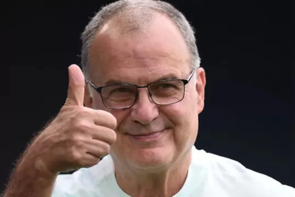 Marcelo Bielsa sonriendo con el pulgar de su mano derecha arriba.