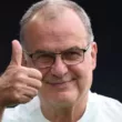 Marcelo Bielsa sonriendo con el pulgar de su mano derecha arriba.