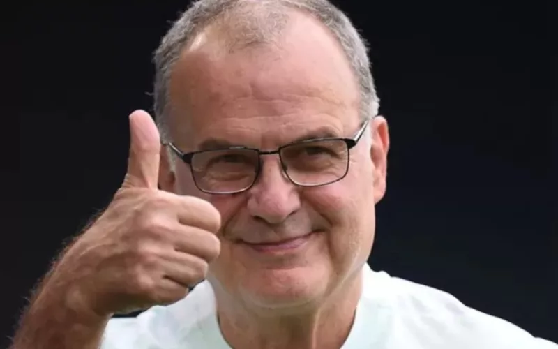 Marcelo Bielsa sonriendo con el pulgar de su mano derecha arriba.