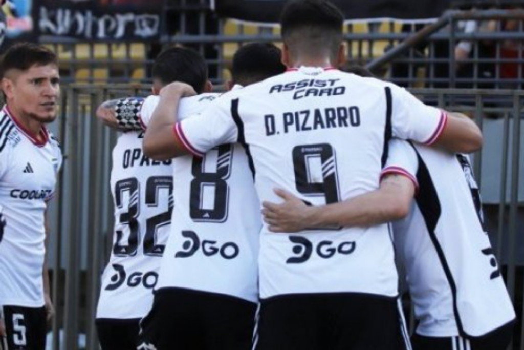 Futbolistas de Colo-Colo se abrazan para festejar un gol.