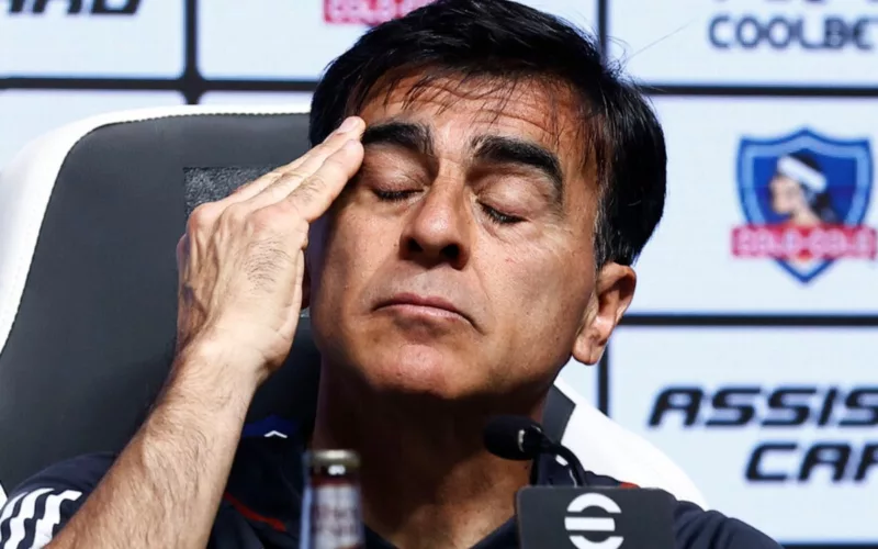 Primer plano de Gustavo Quinteros con los ojos cerrados y su mano en la frente