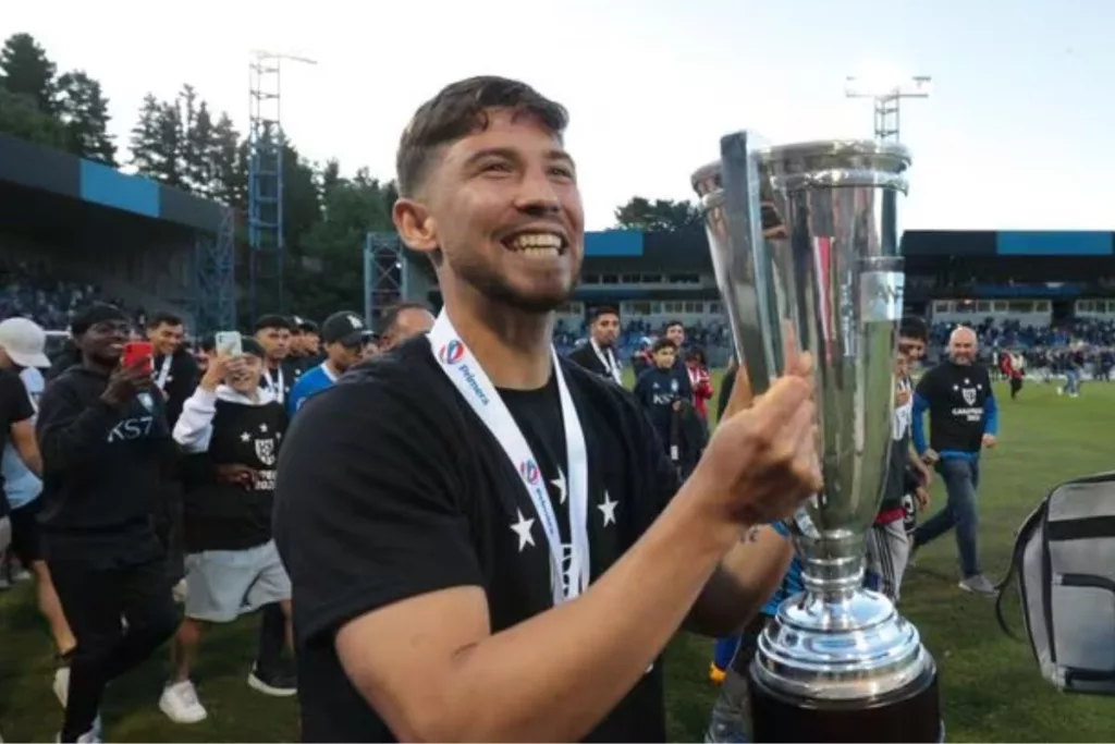 Felipe Loyola sonriendo con el trofeo de campeón en sus manos.