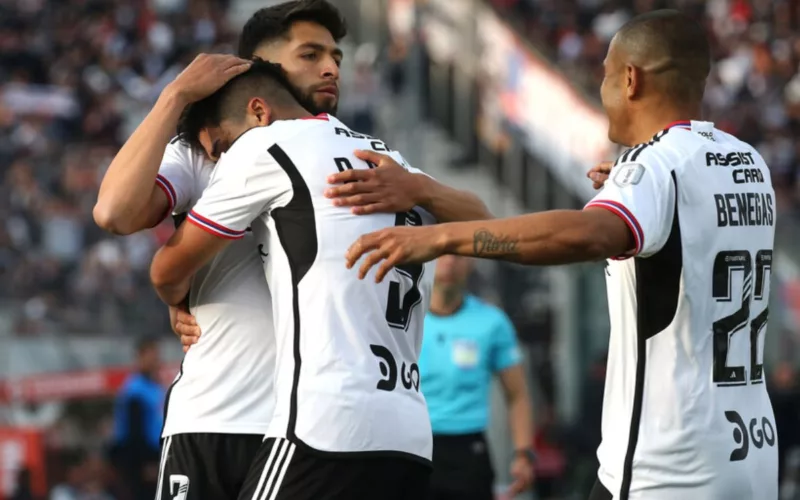 Jugadores de Colo-Colo abrazados festejando un gol