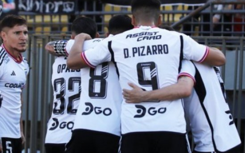 Futbolistas de Colo-Colo se abrazan para festejar un gol.