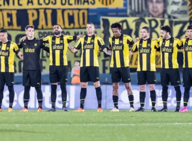 Jugadores de Peñarol abrazados en medio de la cancha