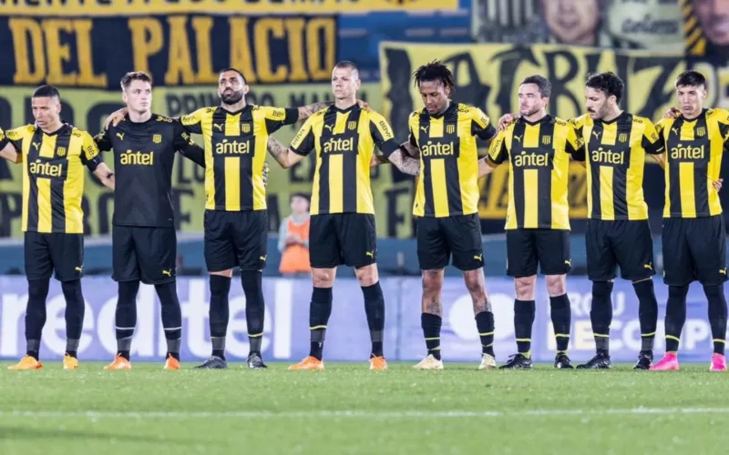 Jugadores de Peñarol abrazados en medio de la cancha