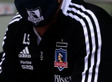 DT con el buzo negro de Colo-Colo y mascarilla con la insignia del club