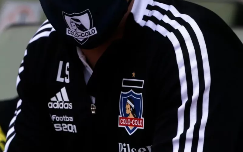 DT con el buzo negro de Colo-Colo y mascarilla con la insignia del club