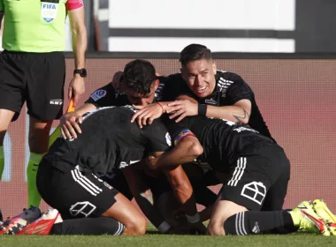 Futbolistas de Colo-Colo se abrazan y celebran un gol durante la temporada 2021 en el Estadio Monumental.