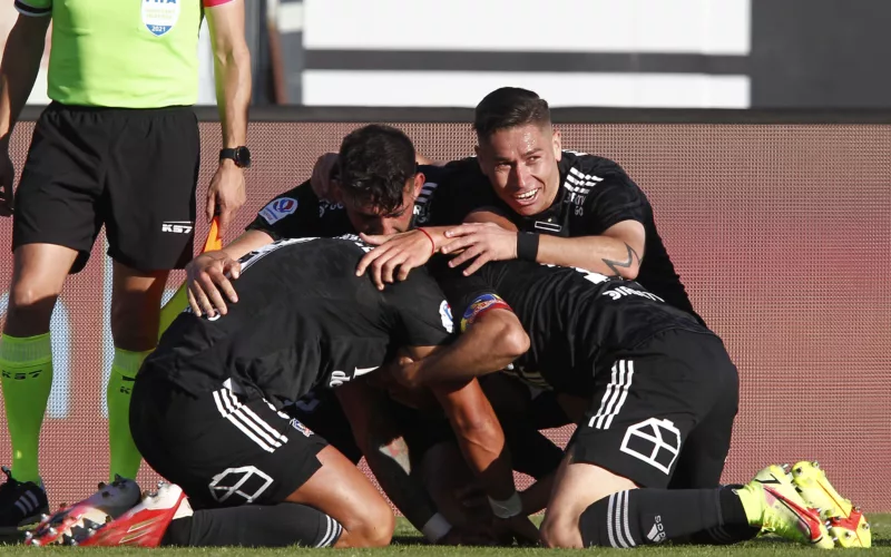 Futbolistas de Colo-Colo se abrazan y celebran un gol durante la temporada 2021 en el Estadio Monumental.