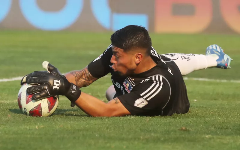 Brayan Cortés atajando un balón en pleno partido con la camiseta de Colo-Colo durante la temporada 2023.