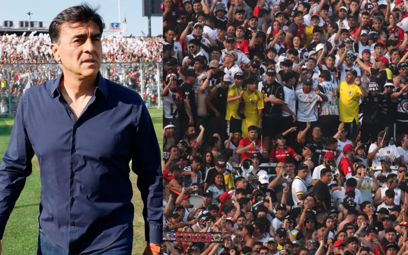 Primer plano a Gustavo Quinteros con camisa y cara de preocupado junto a Garra Blanca en el Estadio Monumental.