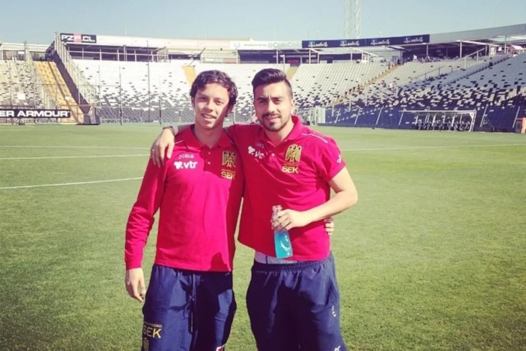 Ramses Bustos abrazado con Mario Larenas con camisetas de Unión Española en el campo de juego del Estadio Monumental, mientras realizan el reconocimiento de cancha previo al duelo frente a Colo-Colo del Torneo de Apertura 2014.