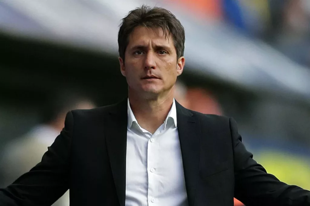 Guillermo Barros Schelotto con los brazos abiertos en un partido de Boca Juniors.