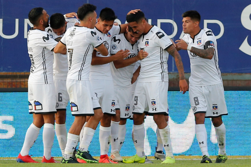 Futbolistas de Colo-Colo se abrazan y celebran un gol durante la temporada 2019.