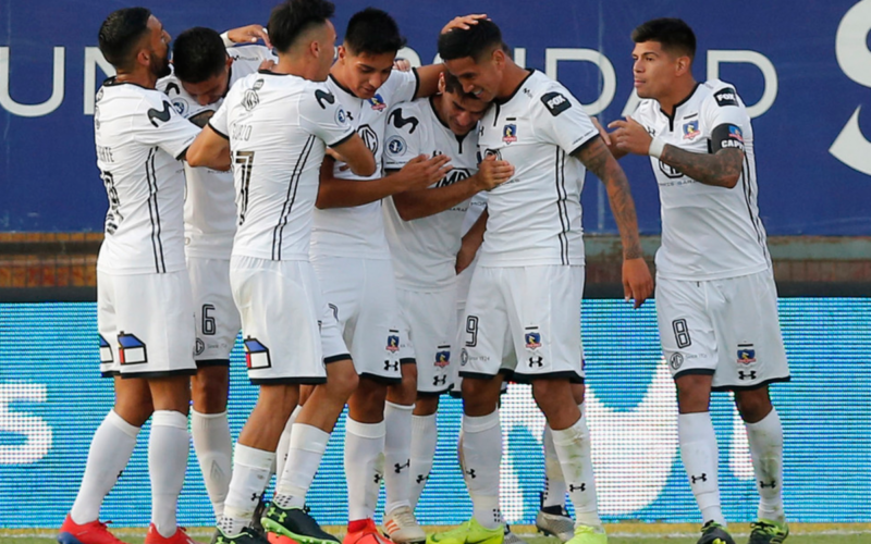 Futbolistas de Colo-Colo se abrazan y celebran un gol durante la temporada 2019.