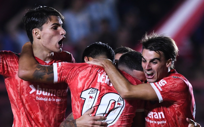 Futbolistas de Argentinos Juniors se abrazan y celebran un gol durante la temporada 2023.