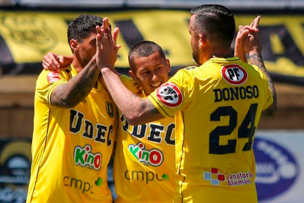 Futbolistas de la Universidad de Concepción se abrazan y celebran un gol a finales de la temporada 2023.
