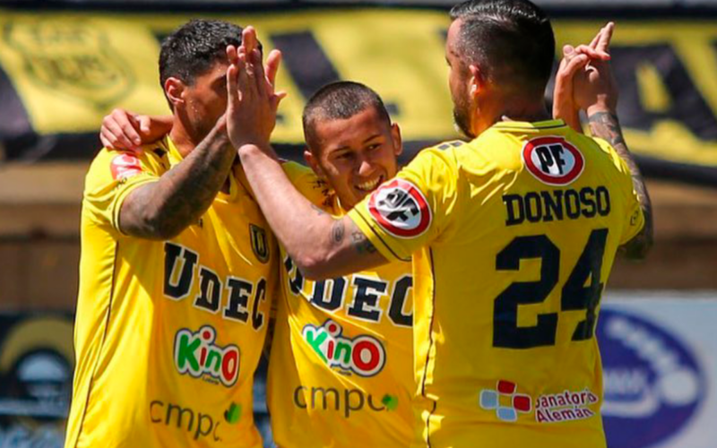Futbolistas de la Universidad de Concepción se abrazan y celebran un gol a finales de la temporada 2023.