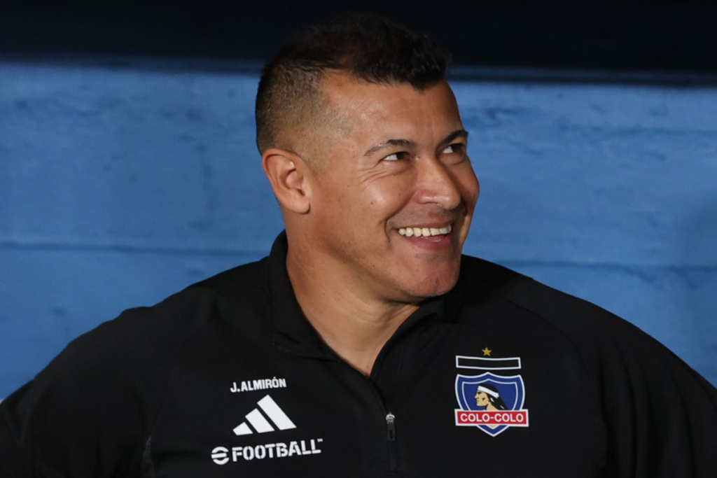 Jorge Almirón sonriente en pleno partido de Colo-Colo durante la temporada 2024.