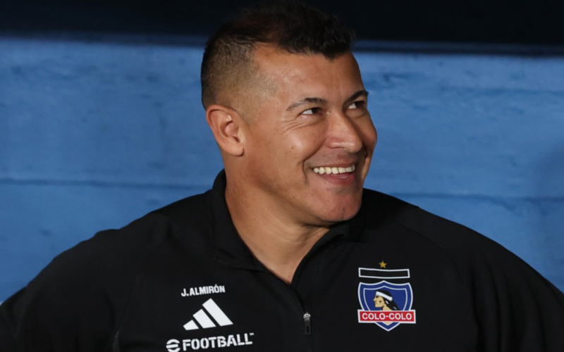 Jorge Almirón sonriente en pleno partido de Colo-Colo durante la temporada 2024.