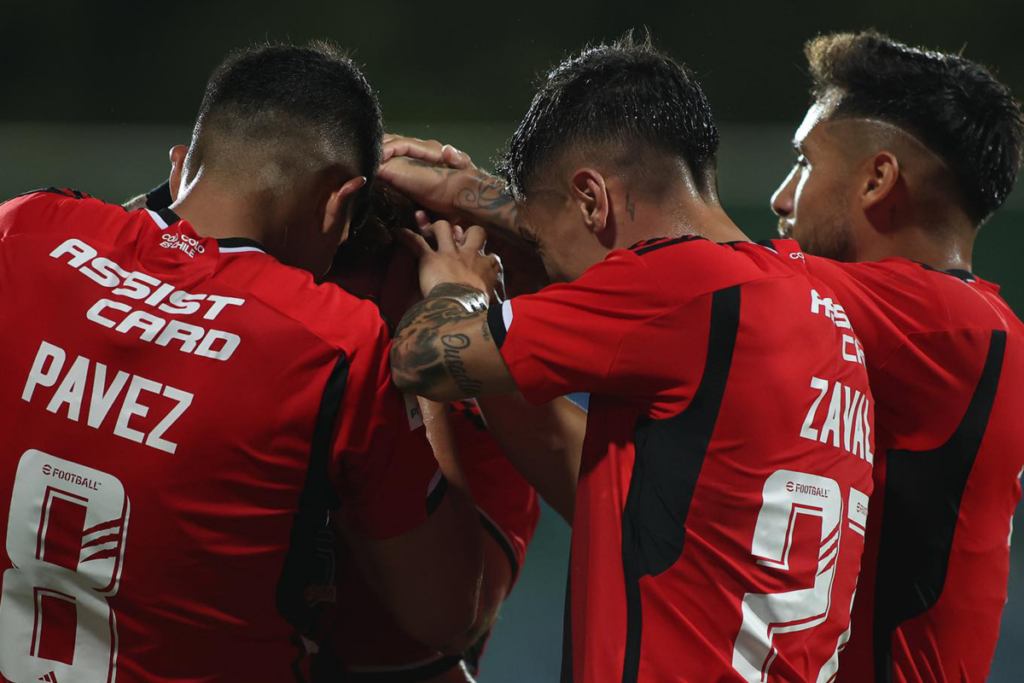Futbolistas de Colo-Colo se abrazan y celebran un gol durante la temporada 2024.