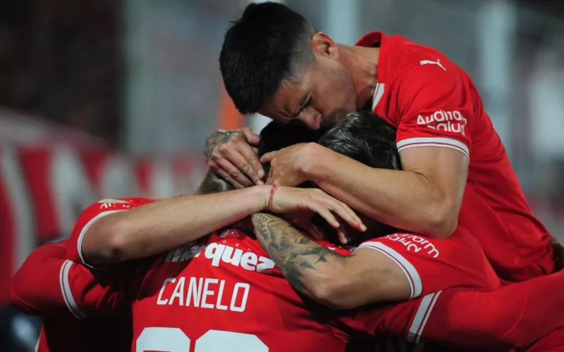 Futbolistas de Independiente de Avellaneda se abrazan y celebran un gol durante la temporada 2023.