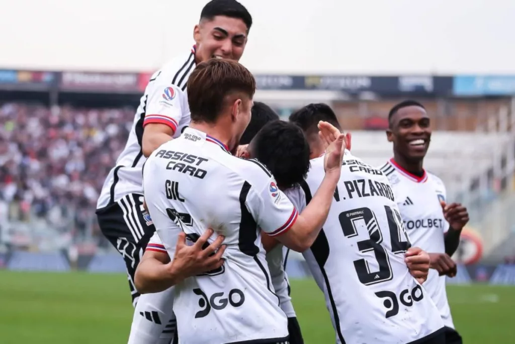 Futbolistas de Colo-Colo celebrando un gol mientras se abrazan