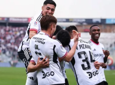 Futbolistas de Colo-Colo celebrando un gol mientras se abrazan