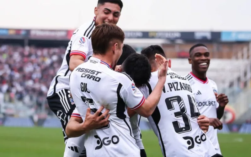 Futbolistas de Colo-Colo celebrando un gol mientras se abrazan