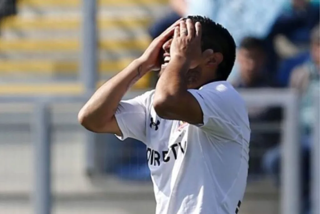 Futbolista de Colo-Colo con las manos en su rostro.