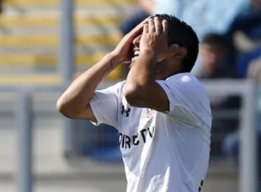 Futbolista de Colo-Colo con las manos en su rostro.