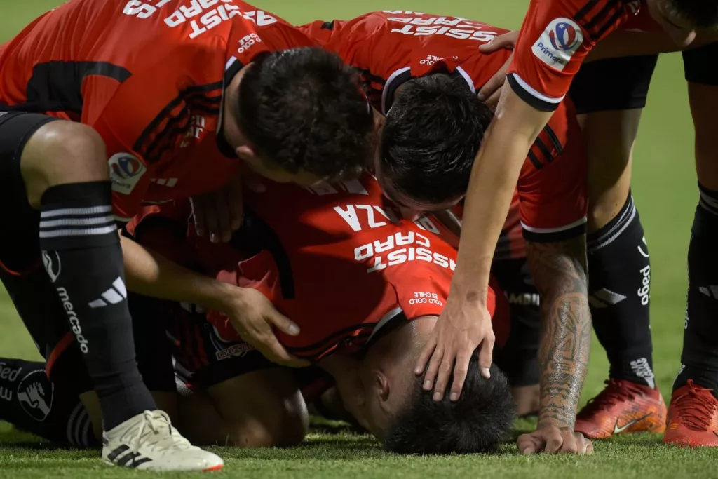 Futbolistas de Colo-Colo arrodillados en la cancha