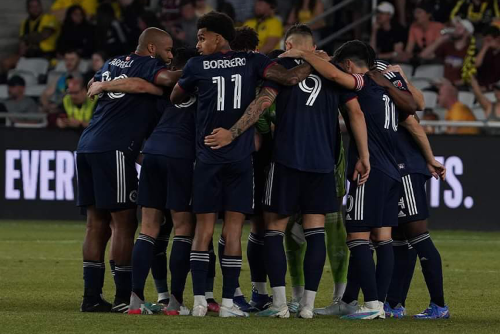 Futbolistas de New England Revolution se abrazan antes de enfrentar un partido por la MLS durante la temporada 2023.